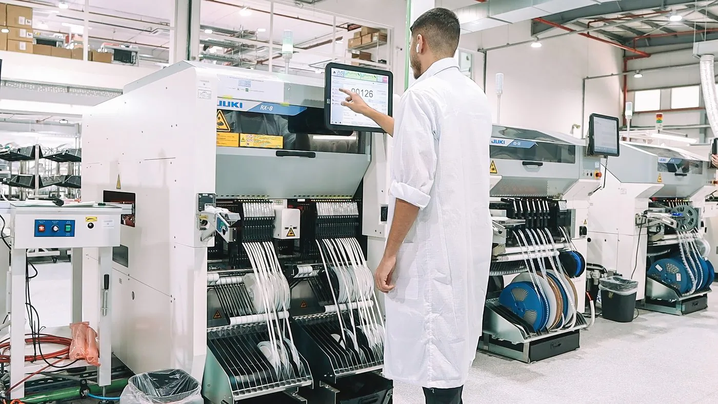Technician at an SMT placement line loaded with component reels